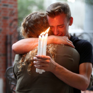 Brett Morian, from Daytona Beach, hugs an attendee during the candlelight vigil at Ember in Orlando, Fla., on Sunday, June 12, 2016.  (Joshua Lim/Orlando Sentinel via AP)